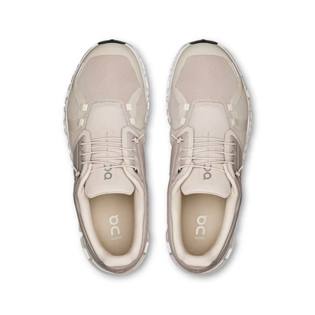 Pair of beige running shoes on a white background